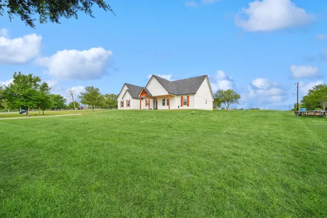 a view of a big yard with a house in the background