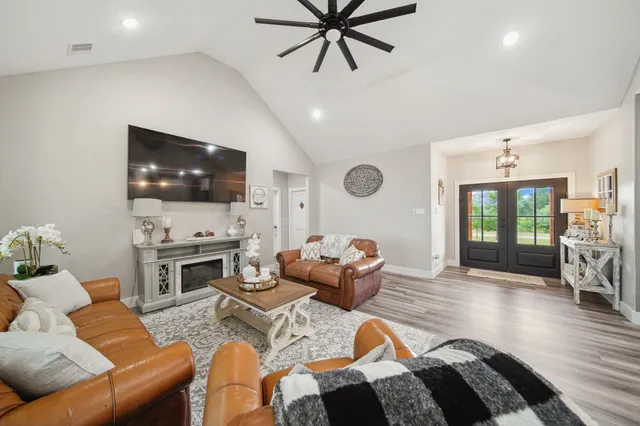 a living room with furniture a flat screen tv and a fireplace