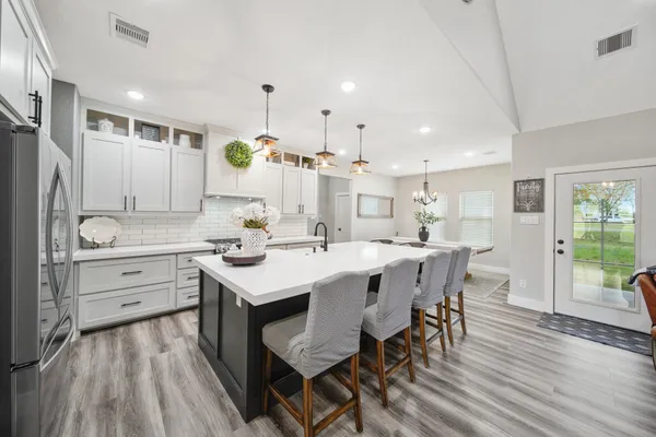 a kitchen with a table chairs appliances and cabinets