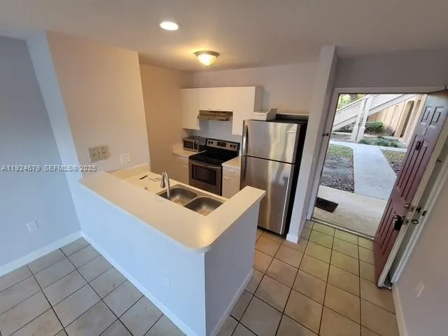 a kitchen with a sink appliances and cabinets