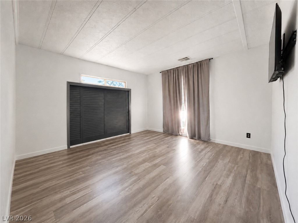 1611 West Blosser Ranch Road Pahrump, NV 89060 - Photo 10 of 25 Natural light streams into this serene space, featuring durable wood flooring and ample storage behind louvered doors.