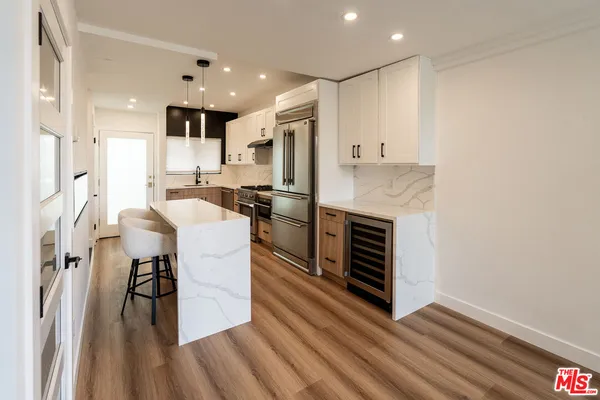 a kitchen with stainless steel appliances kitchen island granite countertop a stove and a refrigerator