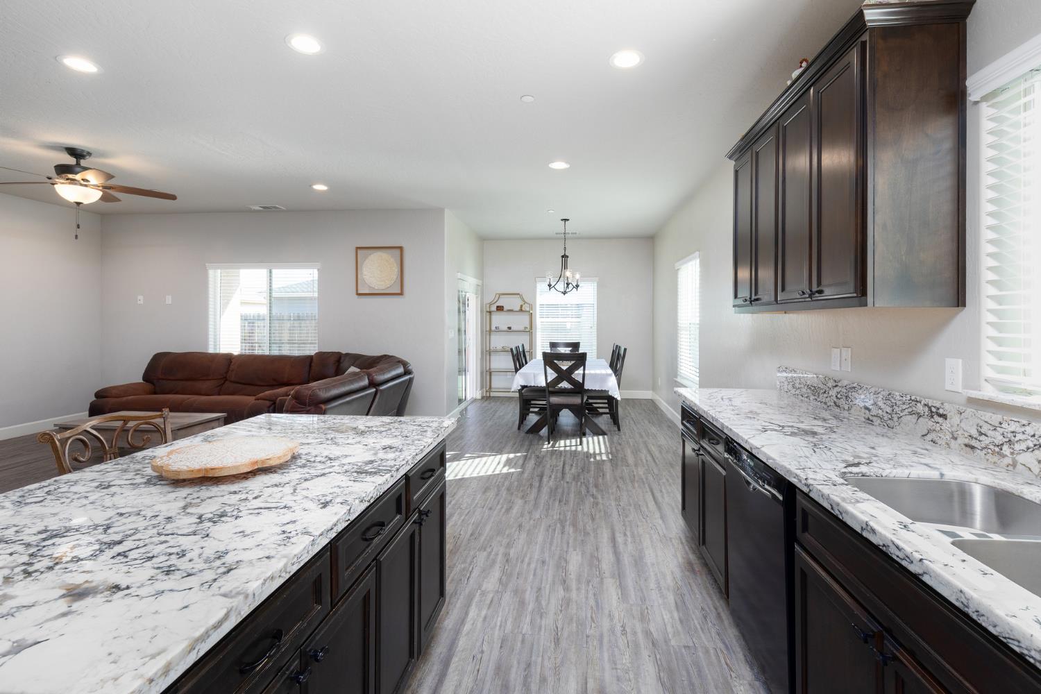 1374 South Enns Avenue Reedley, CA 93654 - Photo 18 of 48 a kitchen with granite countertop lots of counter top space sink stove and living room