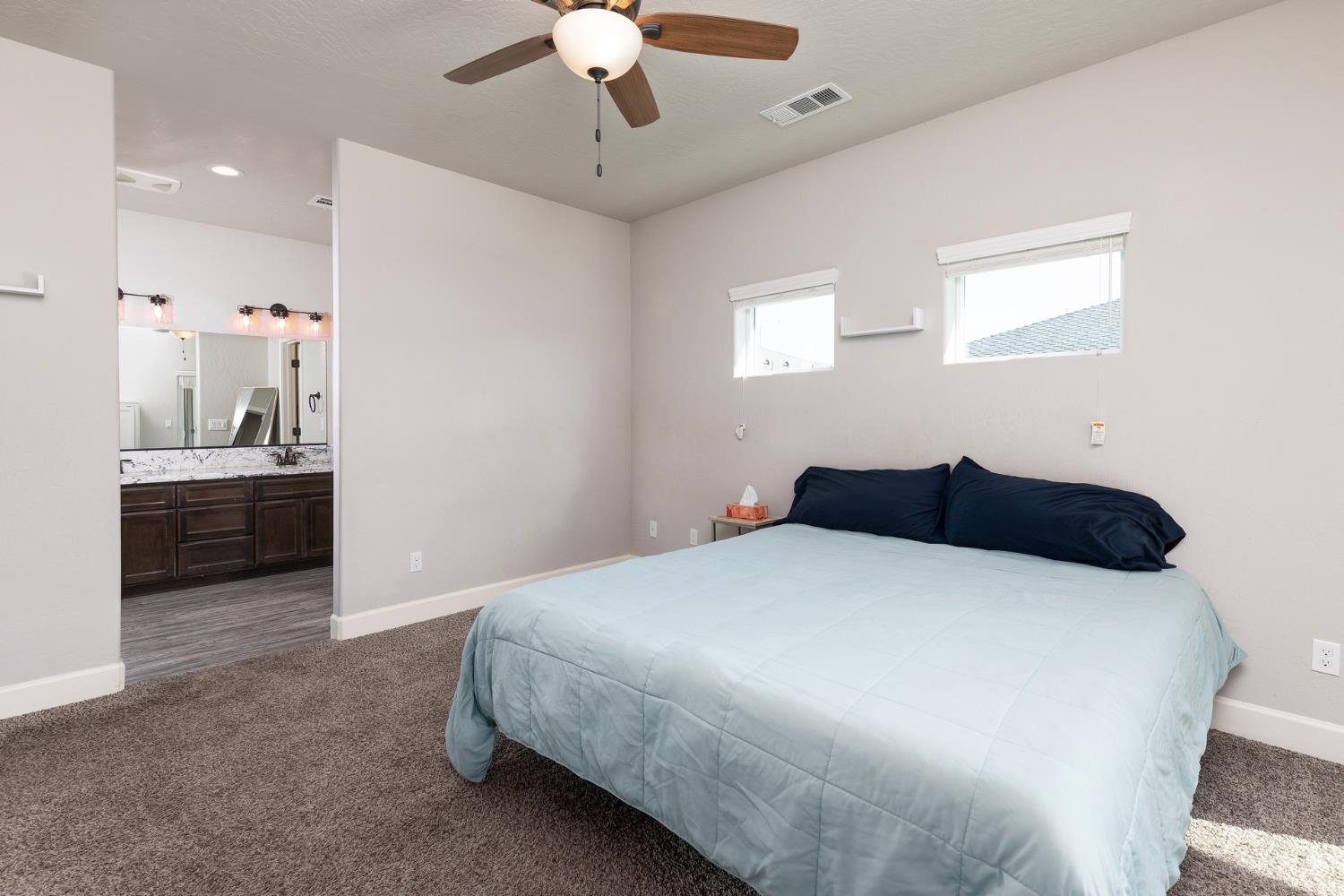 1374 South Enns Avenue Reedley, CA 93654 - Photo 21 of 48 a bedroom with a bed and a chandelier