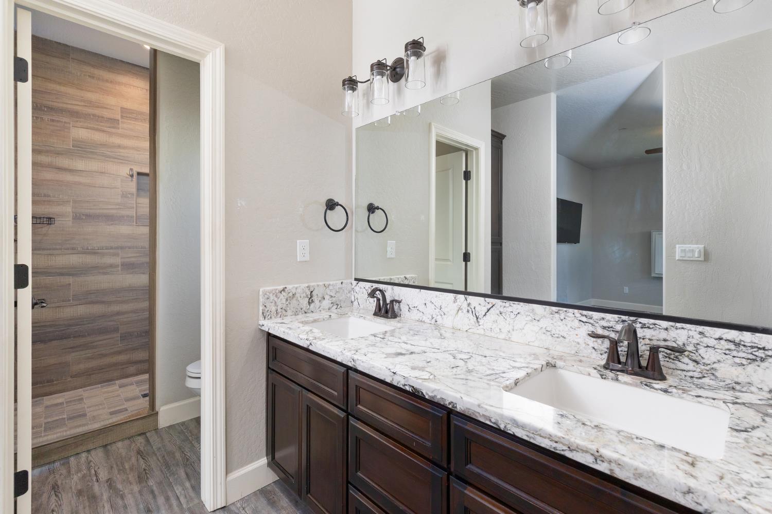 1374 South Enns Avenue Reedley, CA 93654 - Photo 24 of 48 a bathroom with a granite countertop sink and a mirror