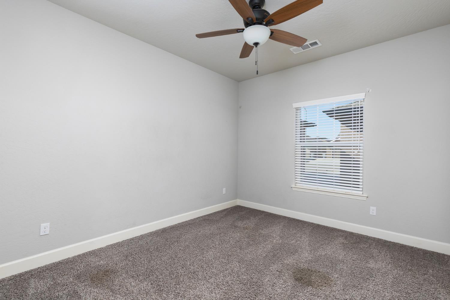 1374 South Enns Avenue Reedley, CA 93654 - Photo 26 of 48 an empty room with a window and a fan