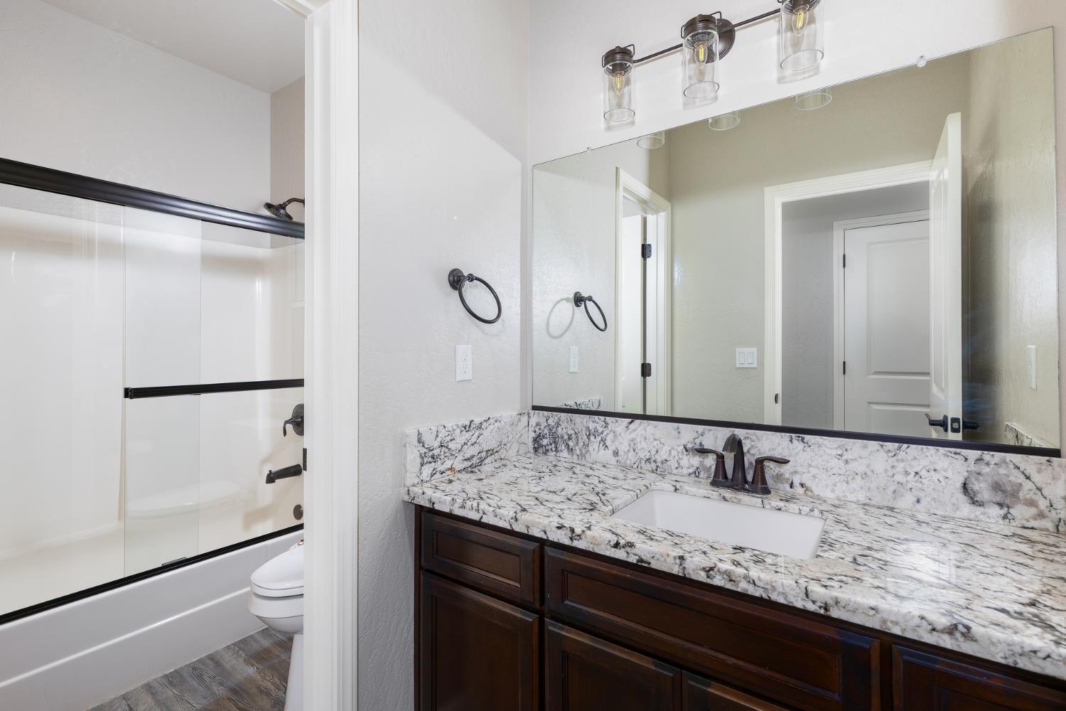 1374 South Enns Avenue Reedley, CA 93654 - Photo 28 of 48 a bathroom with a granite countertop sink and a mirror