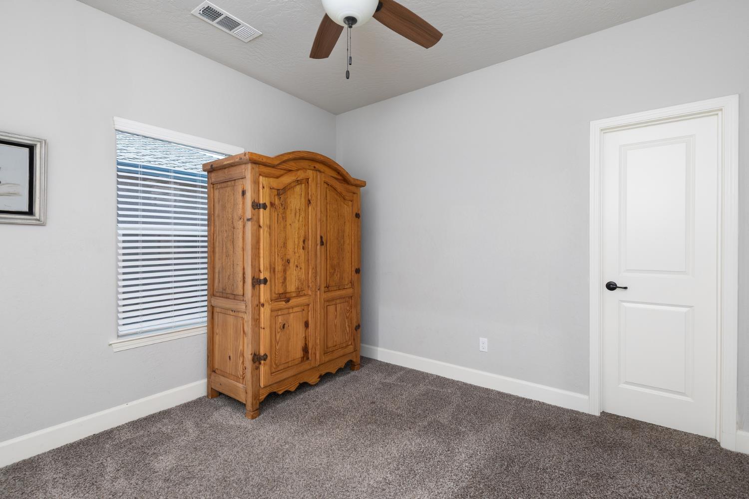 1374 South Enns Avenue Reedley, CA 93654 - Photo 29 of 48 an empty room with window and a ceiling fan