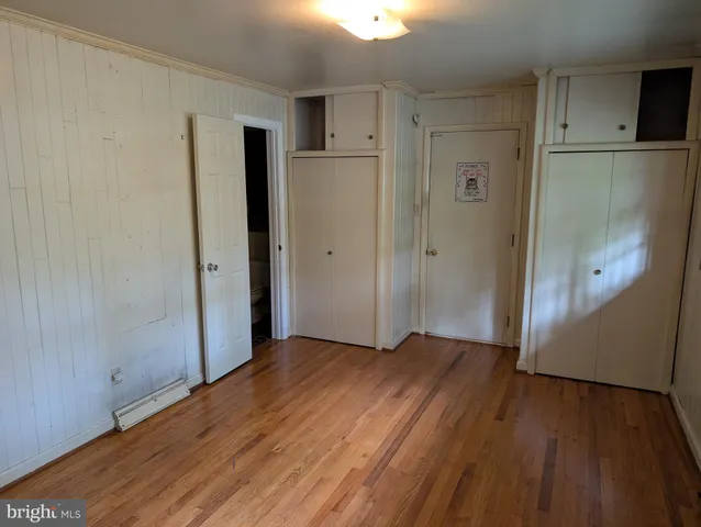 a view of empty room with wooden floor and window