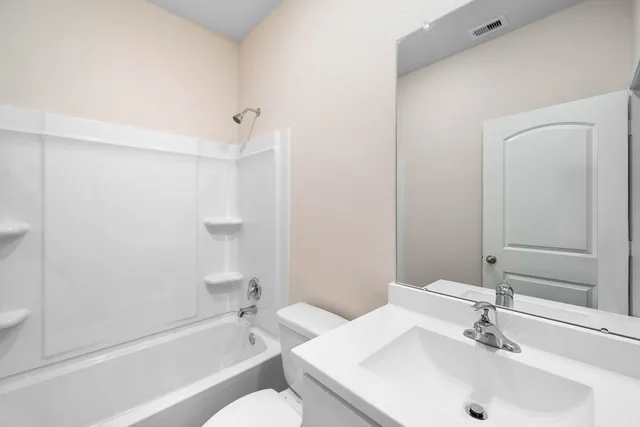 an empty room with window and ceiling fan