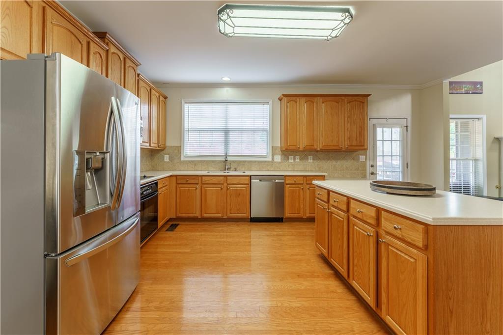 976 Redstone Road Dacula, GA 30019 - Photo 17 of 43 a large kitchen with stainless steel appliances granite countertop a sink a window and a refrigerator
