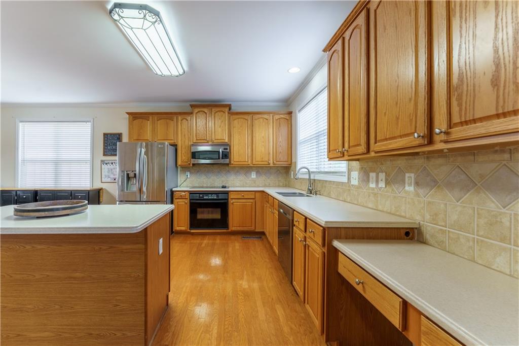 976 Redstone Road Dacula, GA 30019 - Photo 18 of 43 a kitchen with stainless steel appliances granite countertop a sink a stove counter space cabinets and a large window