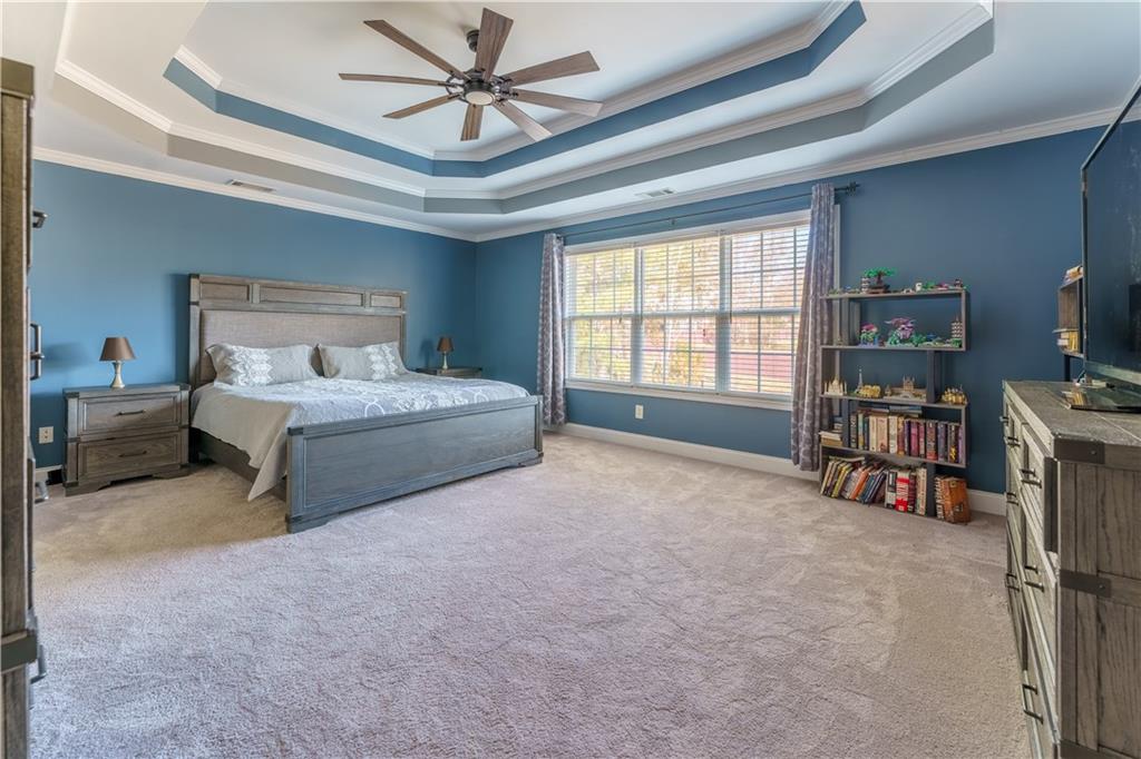 976 Redstone Road Dacula, GA 30019 - Photo 26 of 43 a spacious bedroom with a bed a bookshelf and a book shelf