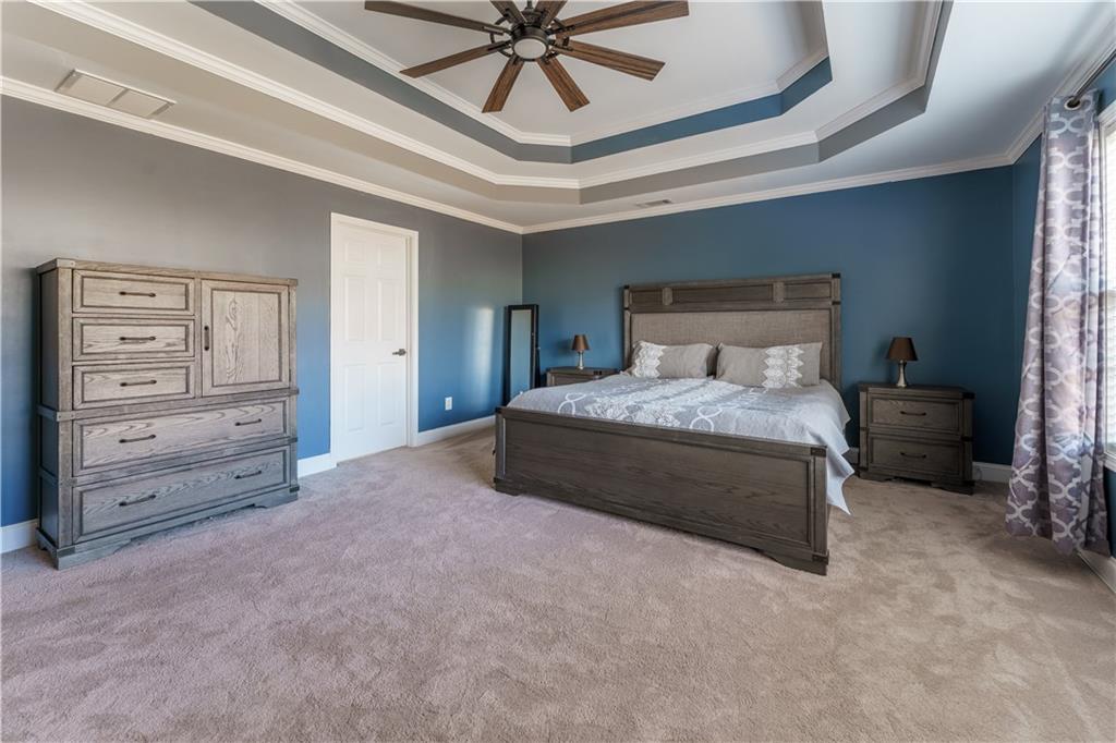 976 Redstone Road Dacula, GA 30019 - Photo 27 of 43 a bedroom with a bed and a chandelier