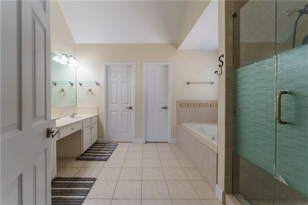 976 Redstone Road Dacula, GA 30019 - Photo 29 of 43 a bathroom with a glass door shower a sink and a mirror