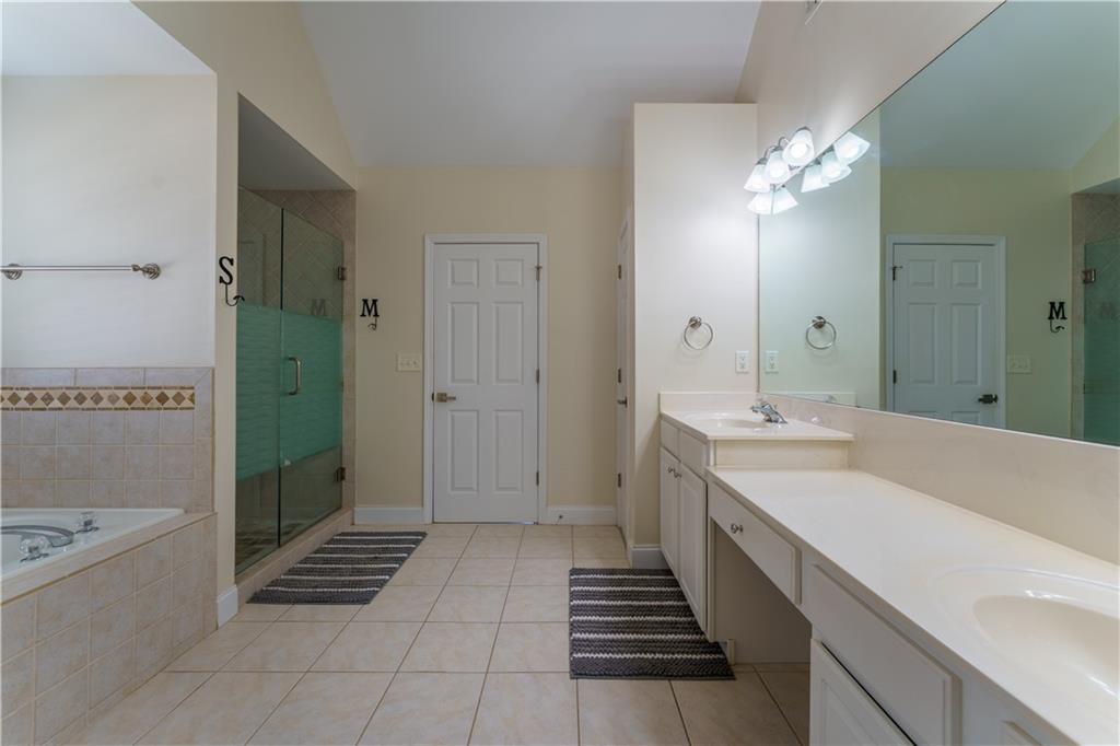 976 Redstone Road Dacula, GA 30019 - Photo 31 of 43 a spacious bathroom with a granite countertop sink a mirror and a bathtub