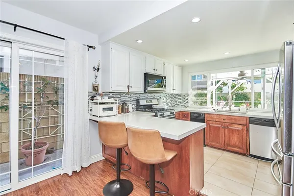 a large kitchen with kitchen island granite countertop wooden cabinets and stainless steel appliances