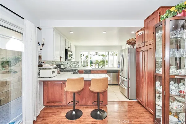 a kitchen with stainless steel appliances granite countertop a table chairs and a refrigerator