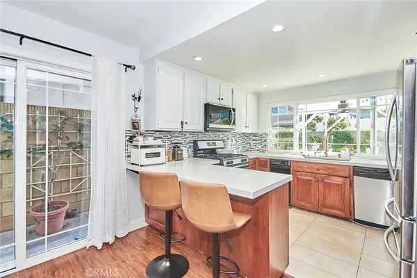 a large kitchen with kitchen island granite countertop wooden cabinets and stainless steel appliances
