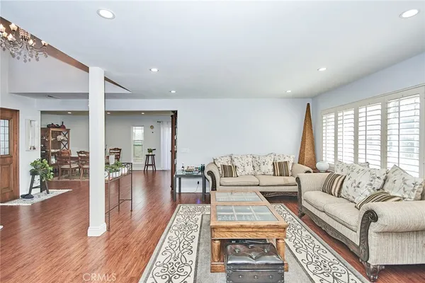 a living room with furniture a wooden floor and next to a window