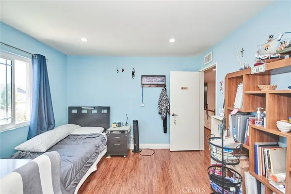 a bedroom with a bed and a wooden floor