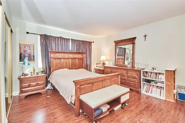 a bedroom with a bed and wooden floor
