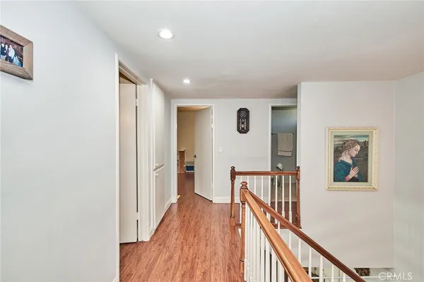 a view of a hallway with wooden floor and staircase