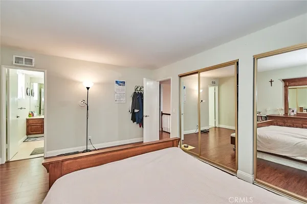 a bedroom with a bed and large mirror