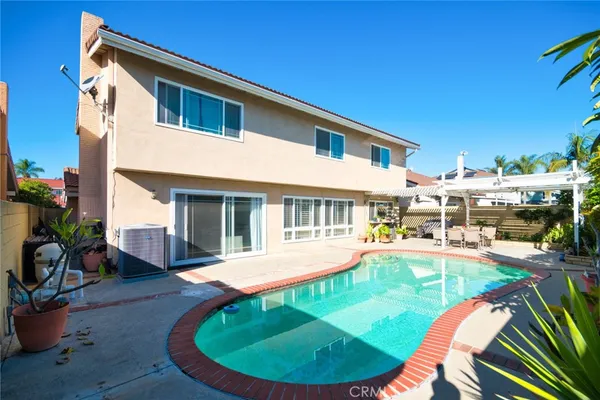 a view of a house with pool and chairs
