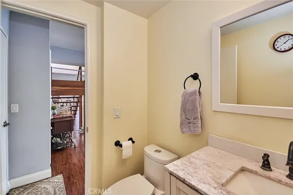 a bathroom with a granite countertop sink a mirror and a toilet