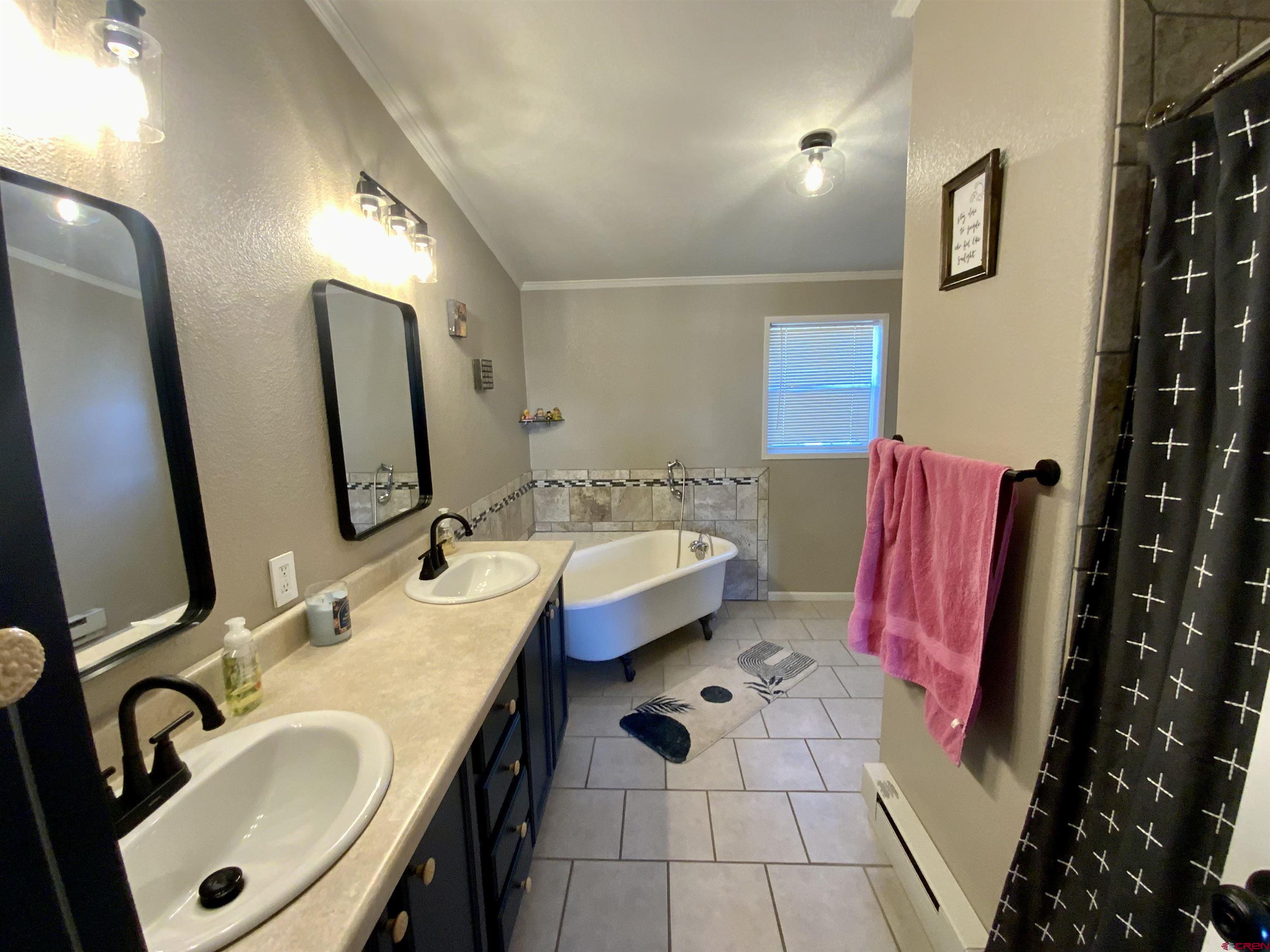 13 Ridge Lane Gunnison, CO 81230 - Photo 12 of 24 a bathroom with a tub sink and mirror