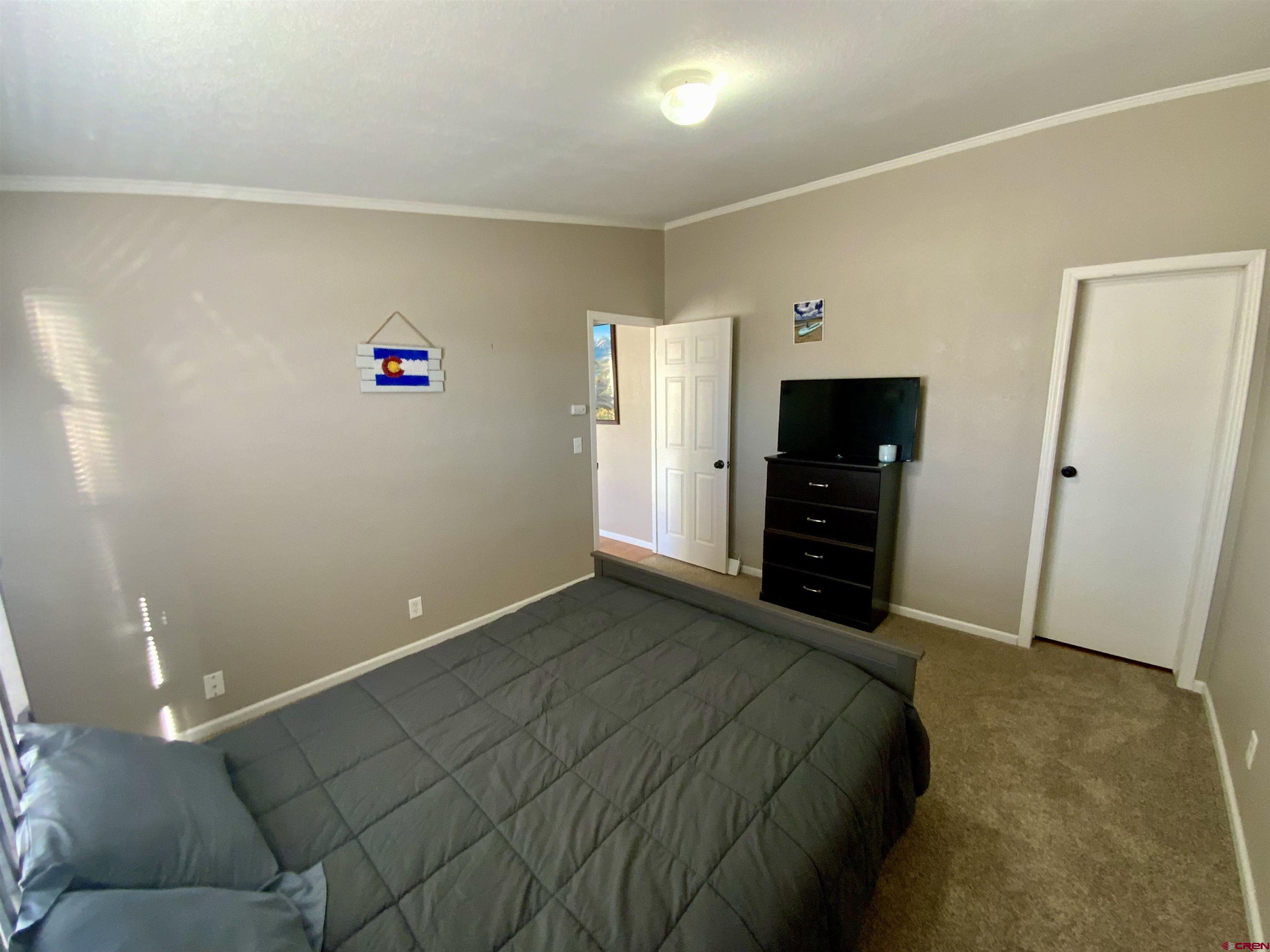 13 Ridge Lane Gunnison, CO 81230 - Photo 16 of 24 a bedroom with a bed and a television