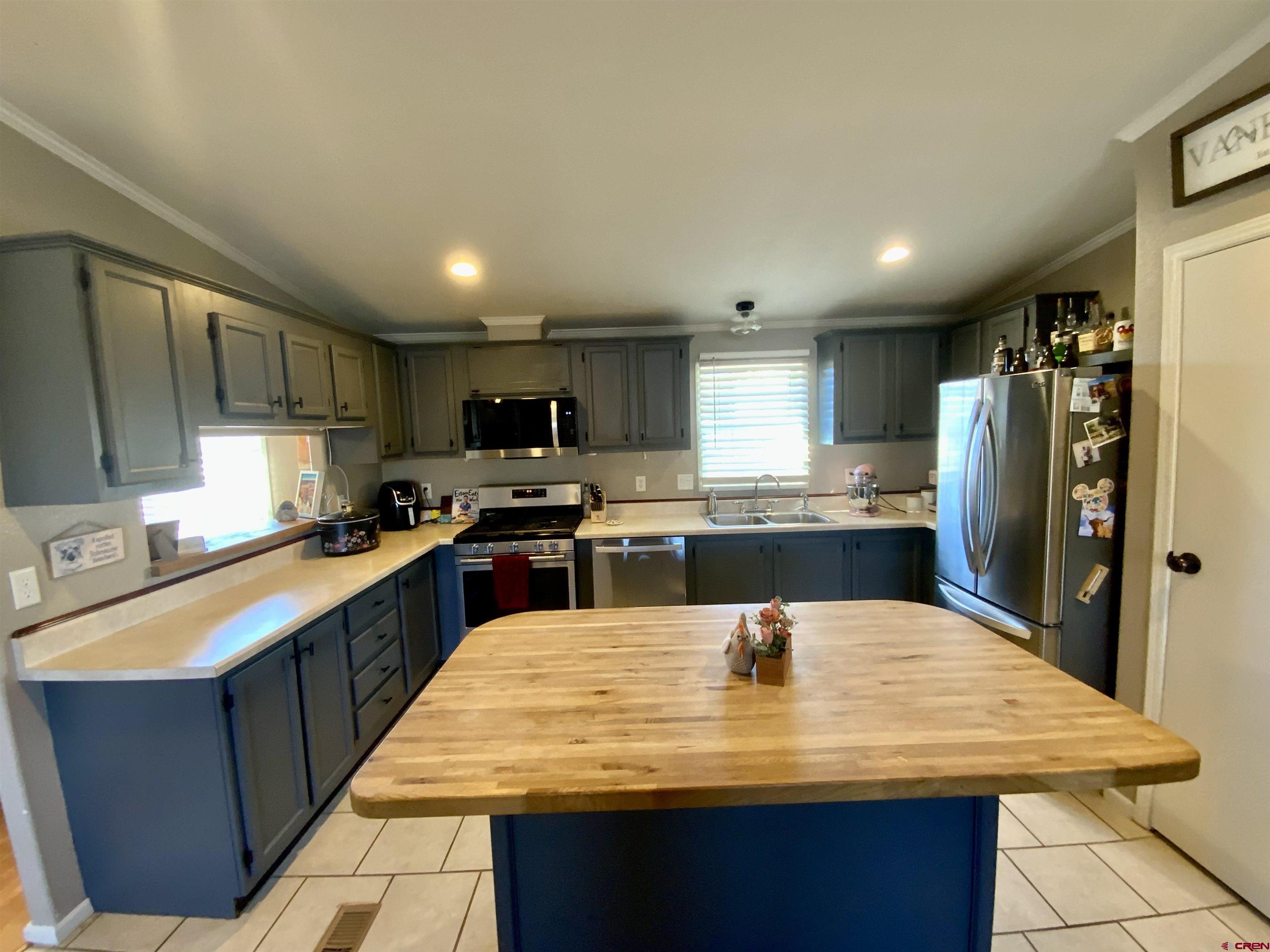 13 Ridge Lane Gunnison, CO 81230 - Photo 5 of 24 a large kitchen with kitchen island a sink a stove a refrigerator cabinets and chairs