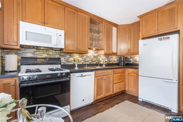 a kitchen with stainless steel appliances granite countertop a stove a refrigerator and a sink