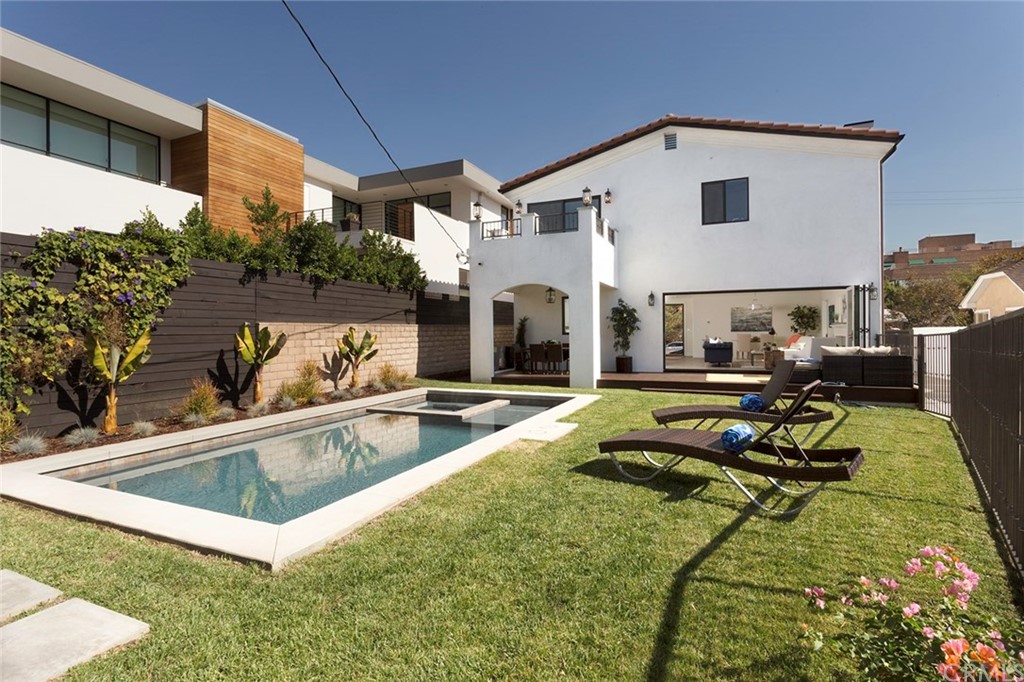 631 North Lucerne Boulevard Los Angeles, CA 90004 - Photo 17 of 21 a view of a white house with a swimming pool and a chairs