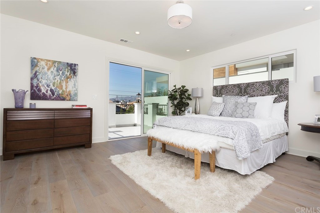 631 North Lucerne Boulevard Los Angeles, CA 90004 - Photo 10 of 21 a bed room with a bed and paintings on the wall