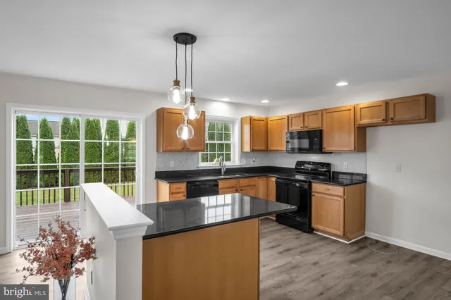 a kitchen with stainless steel appliances granite countertop a sink a stove and a refrigerator