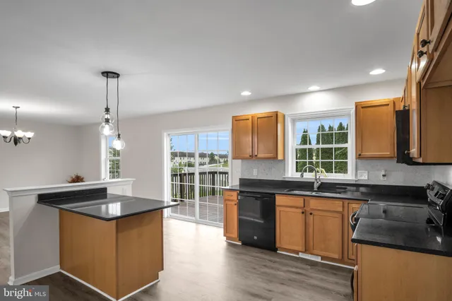 a kitchen with stainless steel appliances granite countertop a sink stove and cabinets