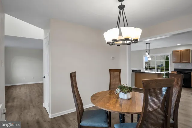 a view of a dining room with furniture a chandelier and wooden floor