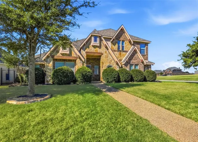 a front view of a house with yard and green space