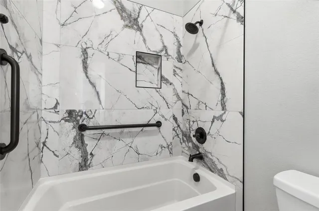 a bathroom with a granite countertop sink a mirror and a shower