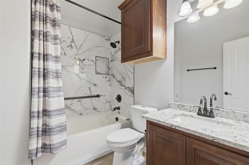 5224 Smokey Ridge Drive Fort Worth, TX 76123 - Photo 29 of 36 a bathroom with a granite countertop sink toilet and shower