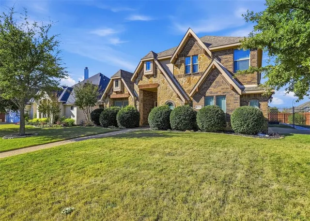 a front view of a house with yard and green space