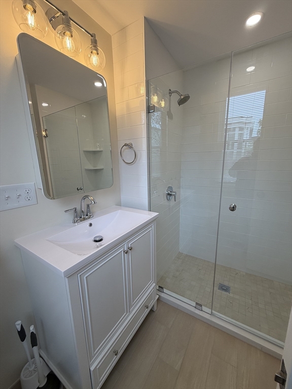 26 Brooks Street, Unit 2 Boston, MA 02128 - Photo 9 of 12 a bathroom with a double vanity sink and mirror