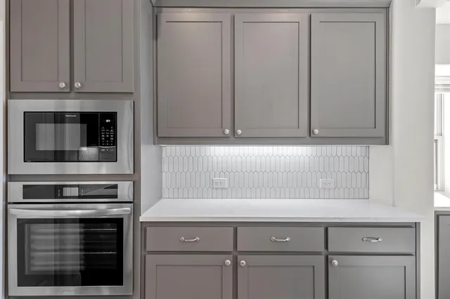 a kitchen with white cabinets and white appliances