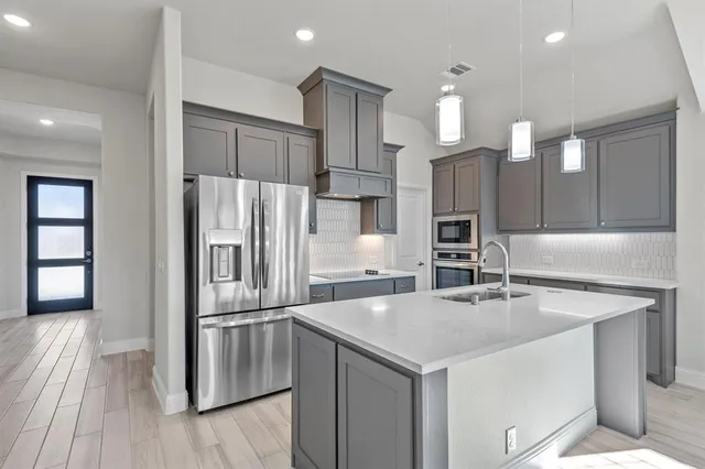 a kitchen with stainless steel appliances a sink and refrigerator