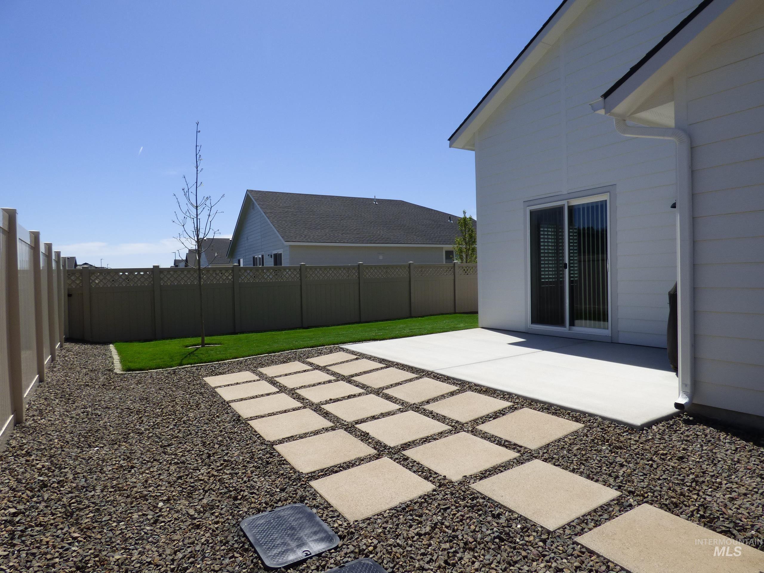 2708 East Buckaroo Drive Kuna, ID 83634 - Photo 43 of 48 Expansive backyard featuring a concrete patio, stepping stone pathway, and a manicured lawn