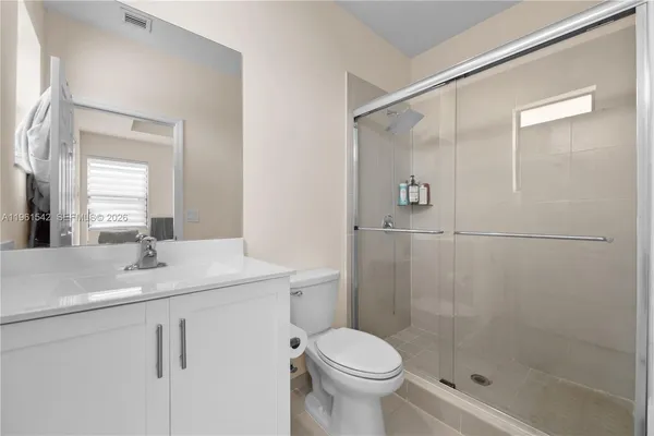 a bathroom with a shower sink vanity and toilet