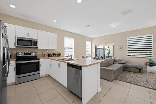 a kitchen with stainless steel appliances kitchen island granite countertop a sink and cabinets