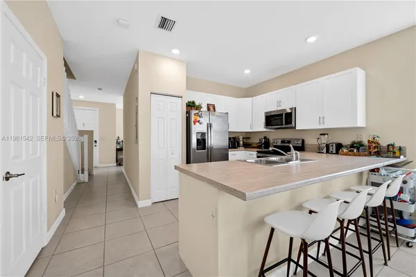 a view of kitchen with refrigerator stove microwave and cabinets